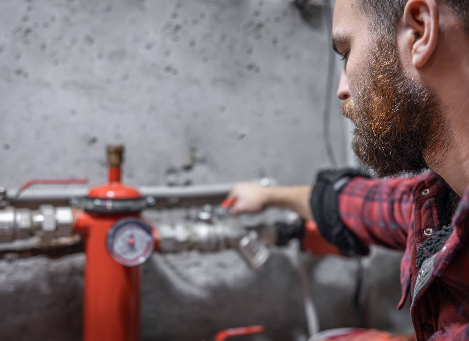 Close-up of technician testing red backflow valve