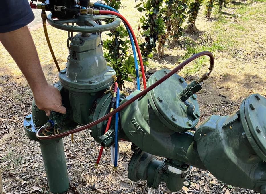 Worker digging to access underground backflow line